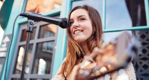 female-musician-busking-playing-acoustic-guitar-QGPZ2UP.jpg